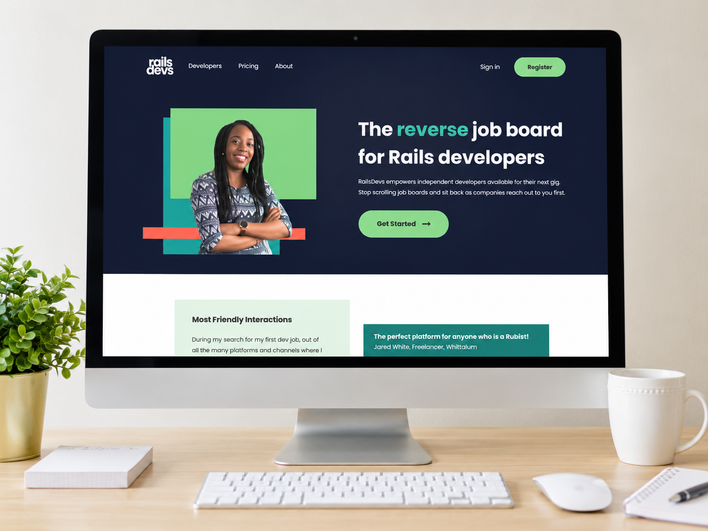 RailsDevs website displayed on a desktop computer on a light wood desk